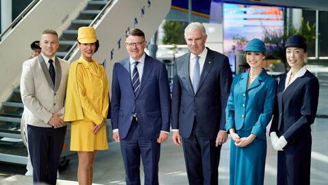 Ministerpräsident Boris Rhein und Lufthansa-Vorstandsvorsitzender Carsten Spohr zusammen mit Stewardessen und einem Steward in Uniformen der vergangenen 100 Jahre